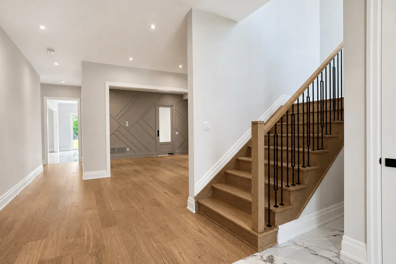 Main hall with oak staircase, iron spindles and panelled room beyond