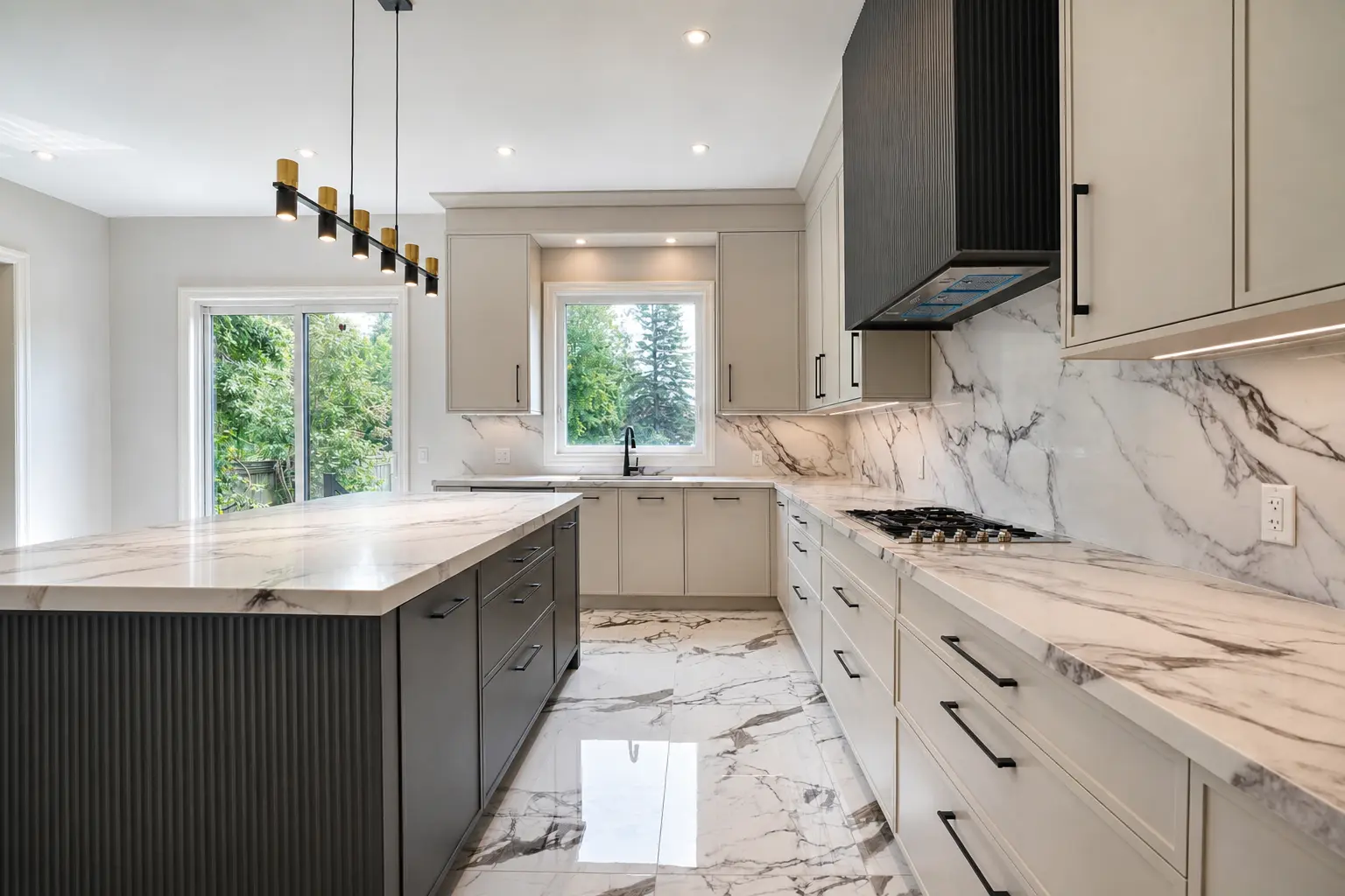 Kitchen with fluted island, marble waterfall counters and black hood