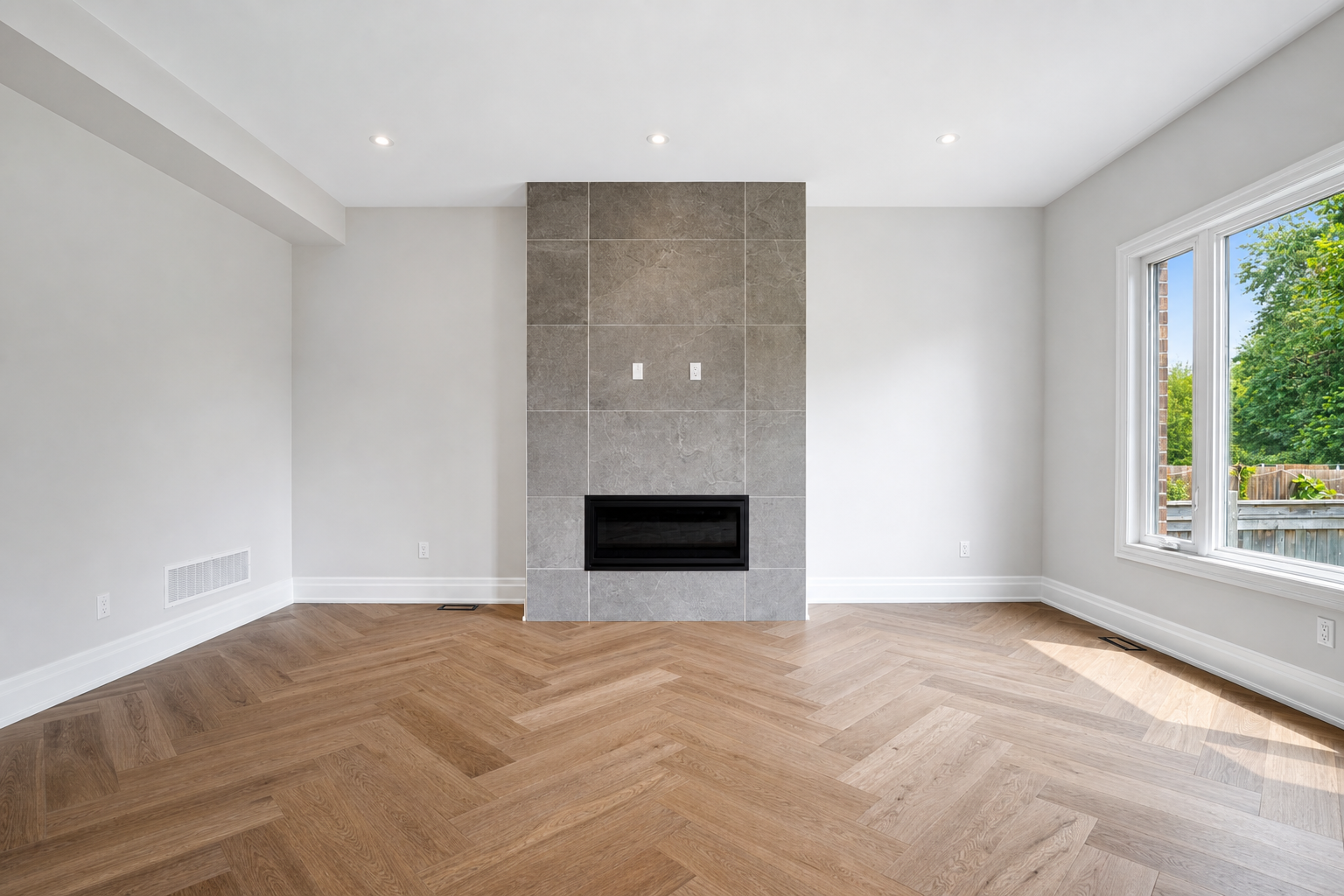 Family room with herringbone oak floors and full-height tiled fireplace