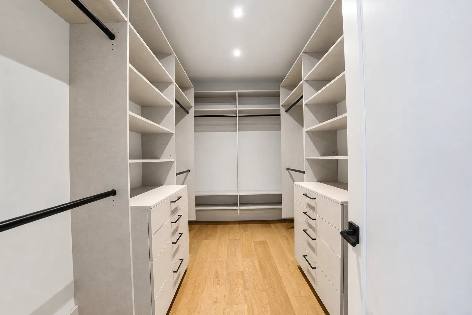 Walk-in closet with custom built-in shelving and drawer banks