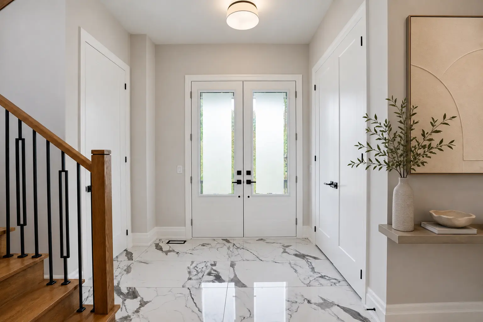 Front foyer with marble-look porcelain floors and oak staircase