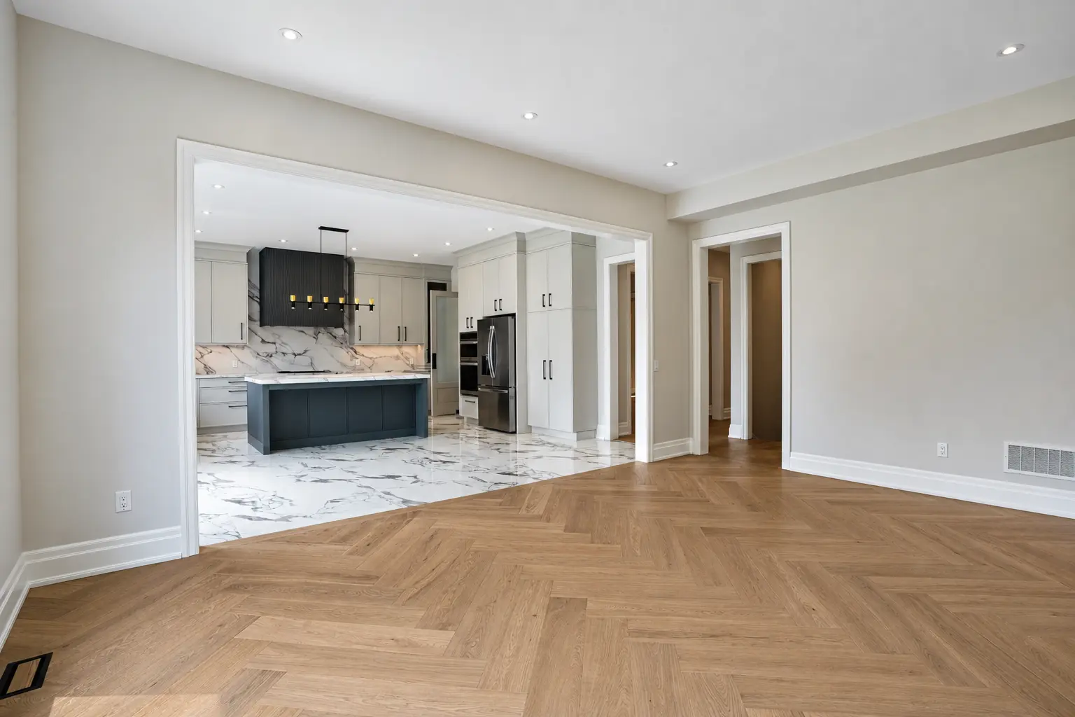 Family room with herringbone oak floors open to the kitchen