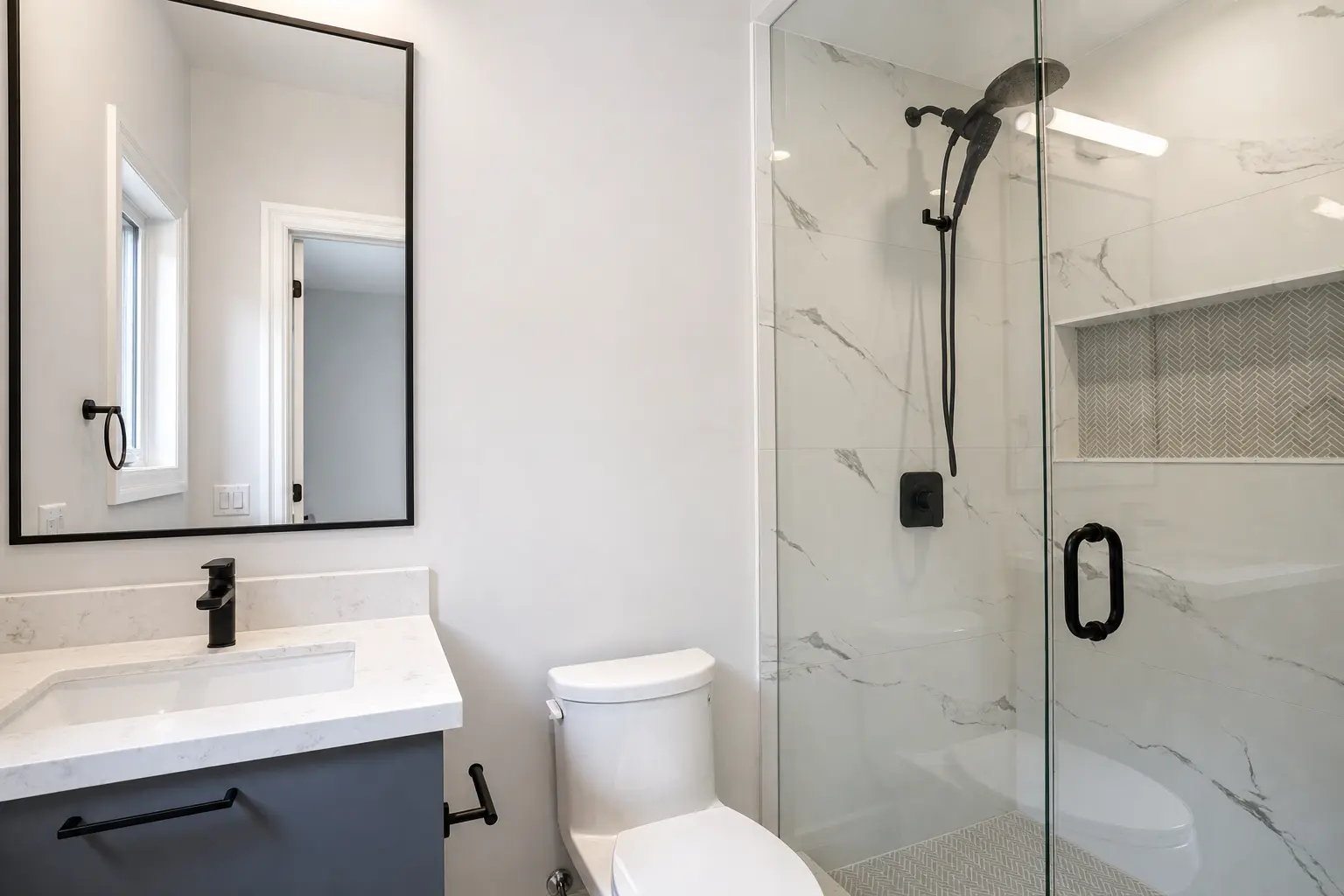 Ensuite bath with glass shower, marble tile and herringbone mosaic niche